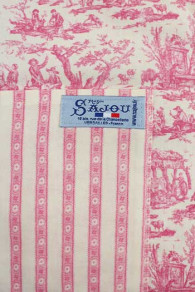 Etiquette Sajou bleu cousue sur un des côtés du tablier toile de Jouy rose pâle
