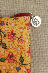 Détail de la fermeture à glissière et du médaillon Sajou argenté sur la trousse Coromandel jaune