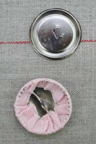 Ein Sajou Knopfrohling aus Metall wird gerade bezogen