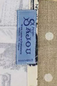 Blue Sajou label sewn on one side of the apron